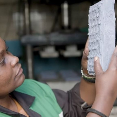 H γυναίκα που ανακυκλώνει κομμάτια πλαστικό και τα μετατρέπει σε τούβλα