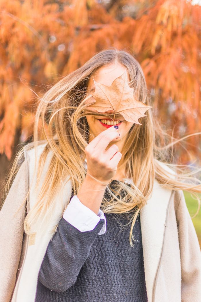 blond-woman-standing-wind-with-autumn-leaf.jpg