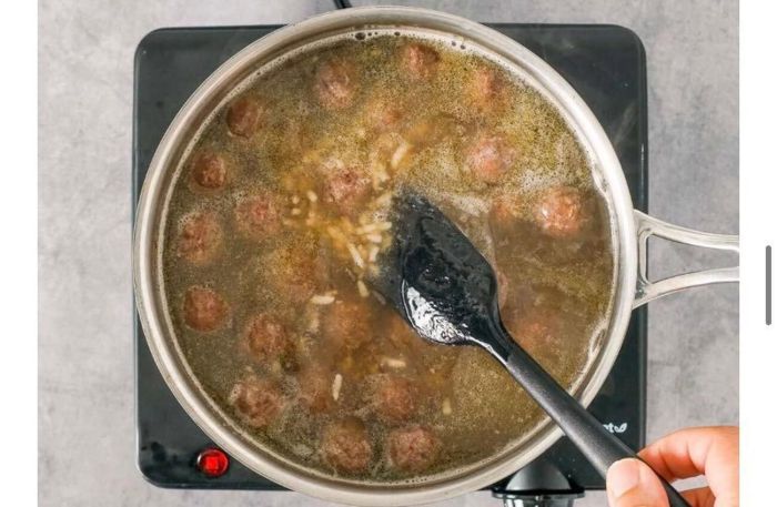Προσθέτεις το ρύζι και τα κεφτεδάκια στον ζωμό και σιγοβράζεις μέχρι να μαλακώσει ελαφρώς το ρύζι και να ενωθούν οι γεύσεις, για 5 με 10 λεπτά.