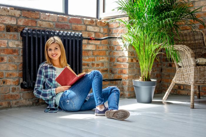 Blond female sitting on the floor and reading a book.