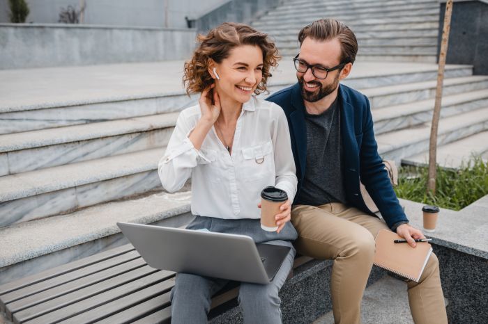 man and woman working together in park