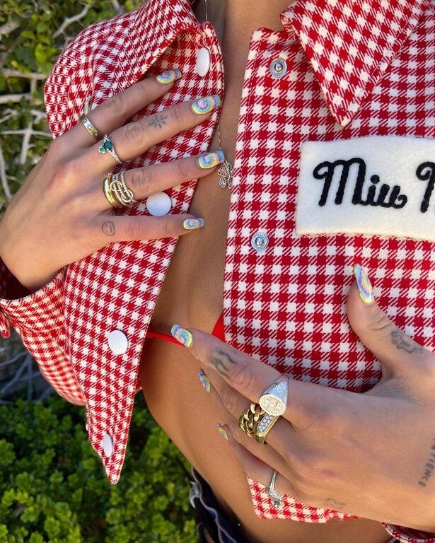 ...μας δείχνει και τα πολύχρωμα νύχια της