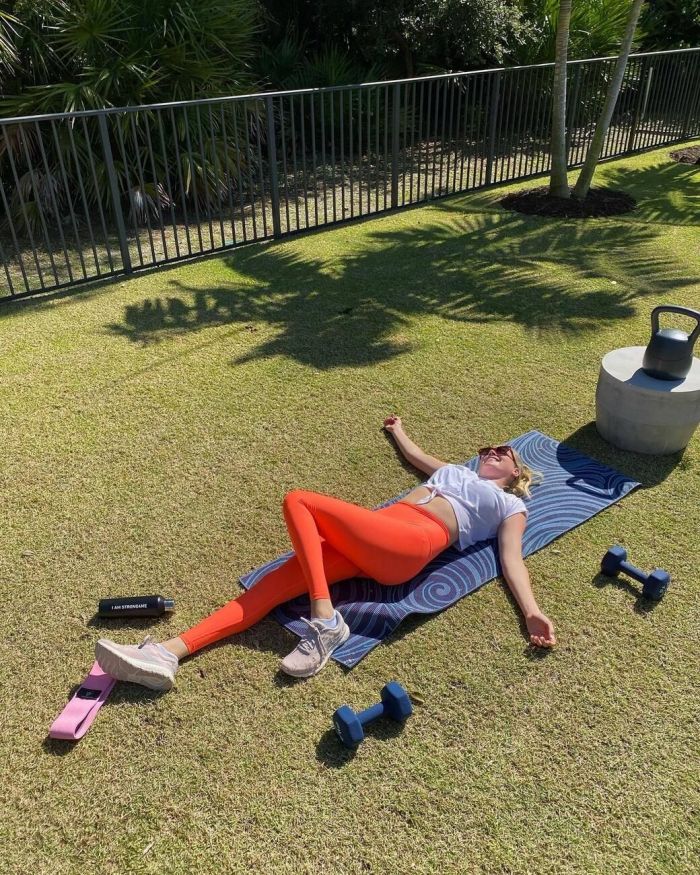 "Τεντώνοντας τα πόδια μου" - Η @kateupton ξαπλωμένη σε στρώμα γυμναστικής φορώντας κολάν και ένα λευκό μπλουζάκι 