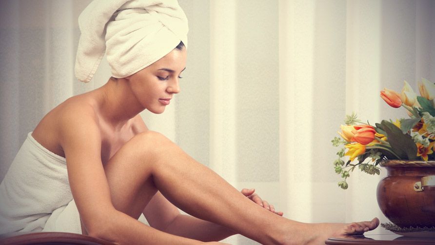 pretty female taking care of her legs after bath