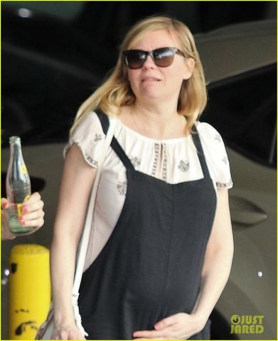 pregnant kirsten dunst cradles baby bump in overalls 06