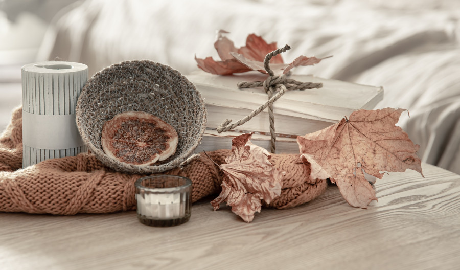 Autumn composition with knitted element, dry leaves and candles.