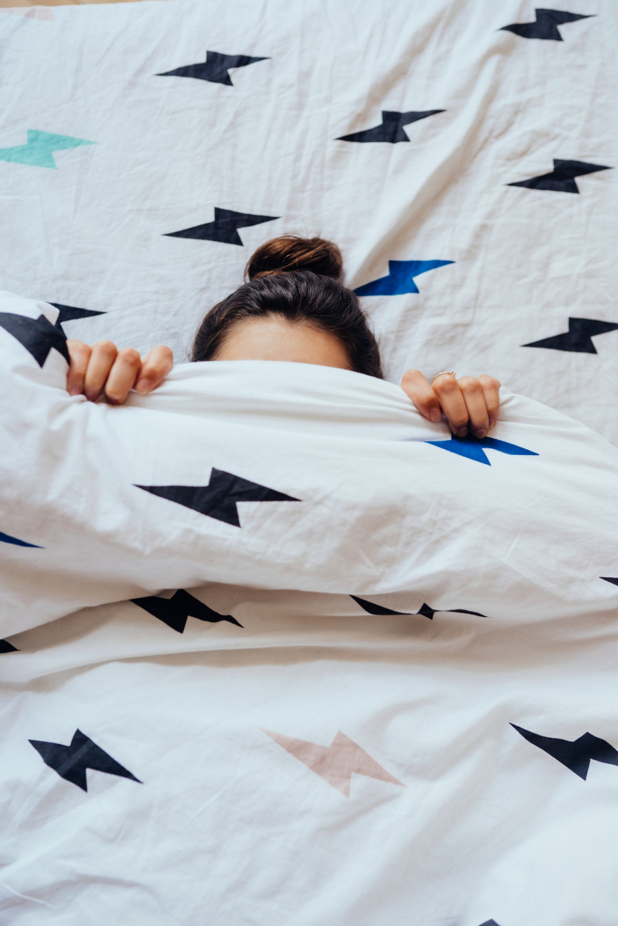Closeup of Lovely young Woman Lies in Bed Covered with Blanket.
