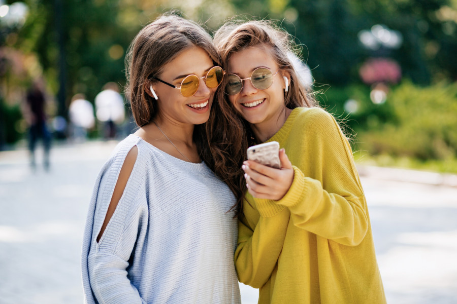 two-funny-smiling-sisters-making-selfie-smaptphone-listening-music-posing-street-vacation-mood-crazy-positive-feeling-summer-bright-clothes-sunglasses.jpg