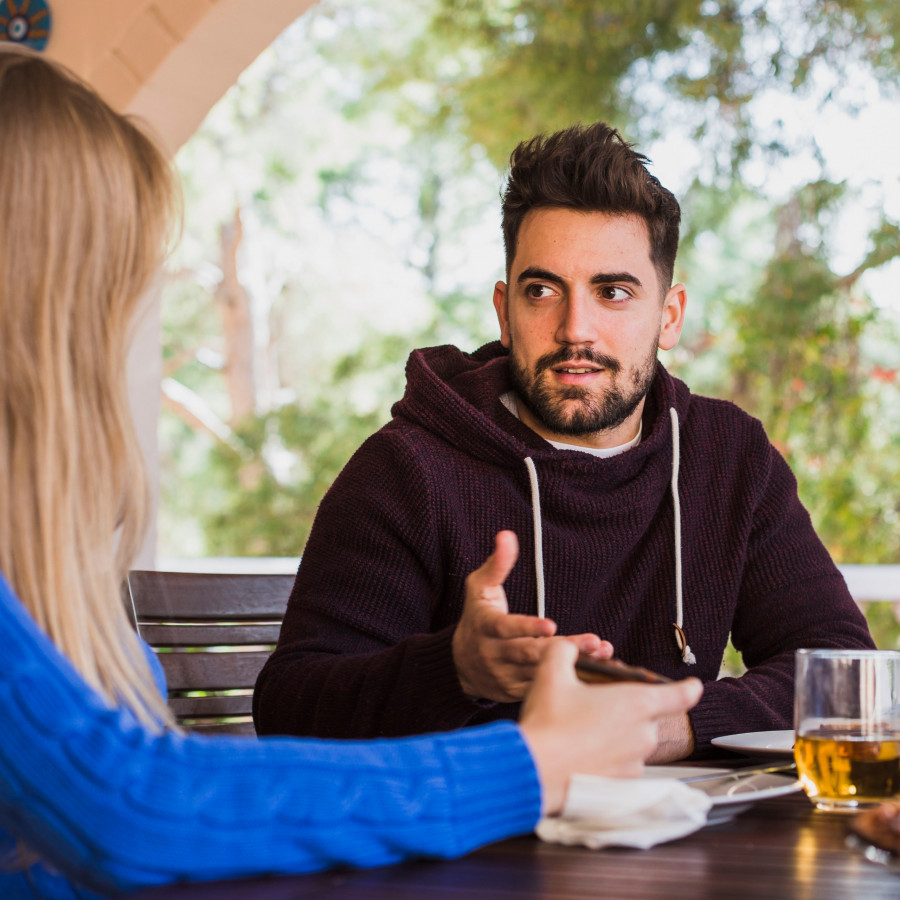 man-talking-woman-table-outdoors.jpg