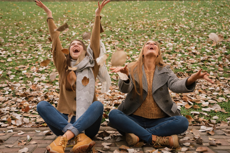 two-women-sitting-playing-with-leaves-park.jpg
