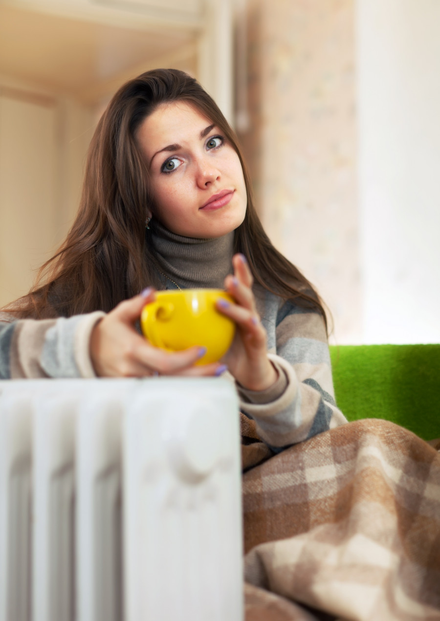 woman near oil heater athome