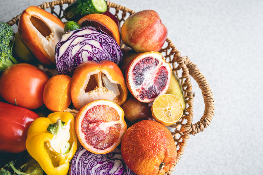 Big basket with fruits and vegetables, close-up.