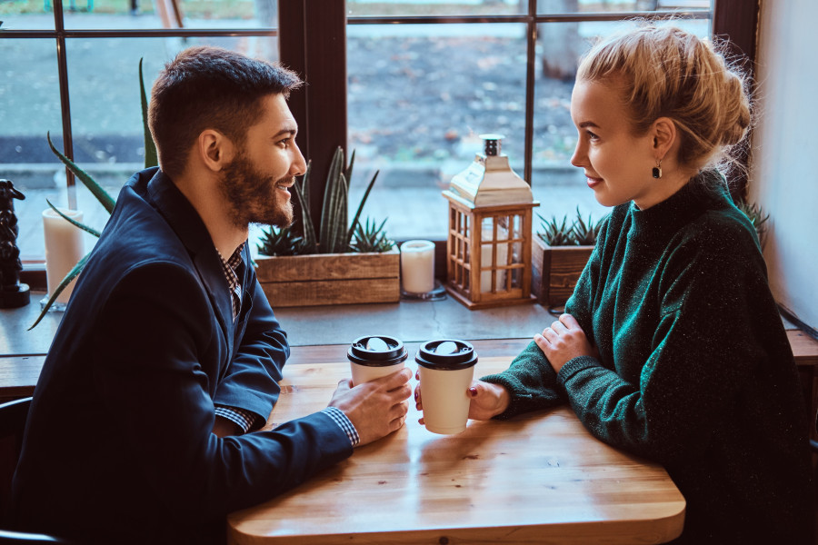 Romantic couple in the cafe is drinking coffee and talking.
