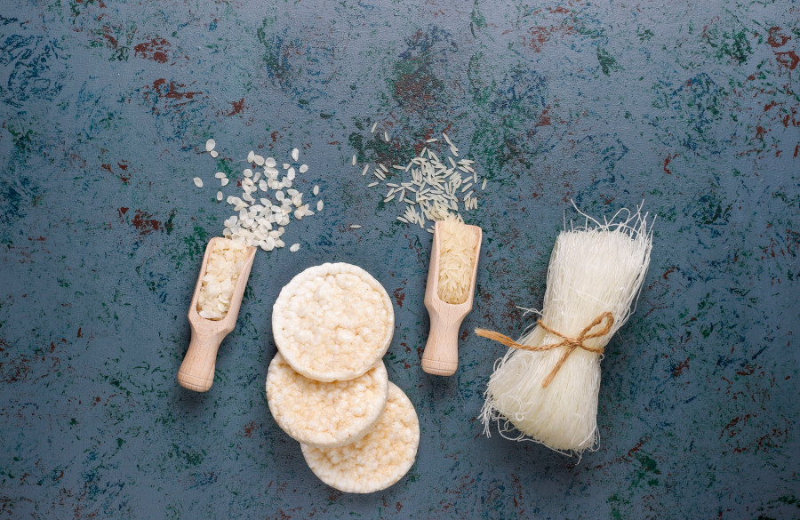 Rice flakes,rice noodles,rice bread and rice on dark background,top view